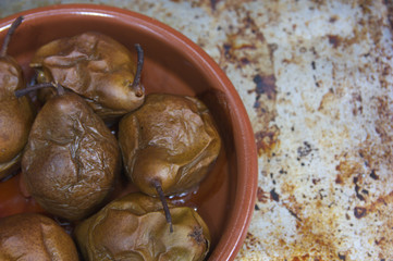 A clay casserole contains freshly baked pears