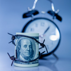 Economic warfare, sanctions and embargo busting concept. US Dollar money wrapped in barbed wire and...