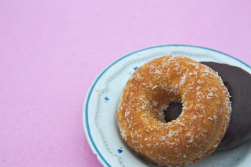 Image of two different colored doughnuts on a plate and space for texts
