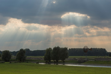 River bed floodplain meadow landscape with Jacob's ladder sun rays