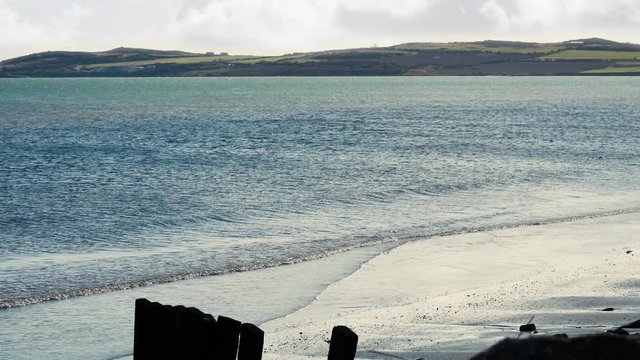 Gentle waves lapping against sandy shore near Annagassan in County Louth
