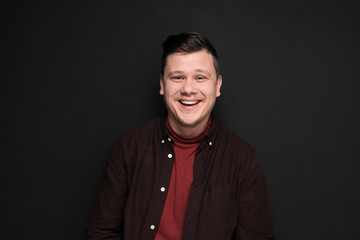 Obraz premium Portrait of young laughing man isolated on gray background