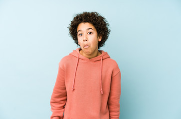 African american little boy isolated shrugs shoulders and open eyes confused.