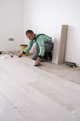 worker installing the ceramic wood effect tiles on the floor