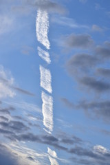 Natur als Künstlerin - Wolkengebilde Kondensstreifen, blau grau weiß Hintergrund.