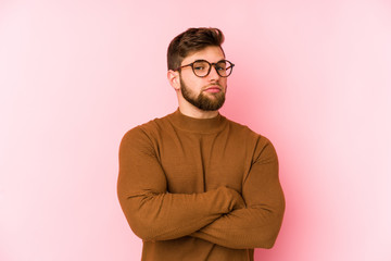Obraz premium Young caucasian man isolated on pink background suspicious, uncertain, examining you.
