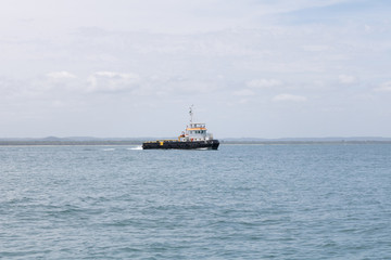 Tug boat in the middle of the ocean. Morro de Sao Paulo, Salvador, Brazil. Hill.