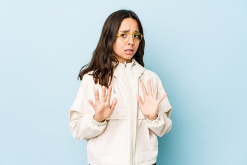 Young mixed race hispanic woman isolated rejecting someone showing a gesture of disgust.