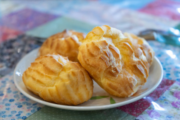 eclairs in white ceramic plate on table in cafe