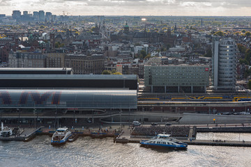 Historic city centre of Amsterdam with train station in the foreground seen from across the river IJ from a high vantage point