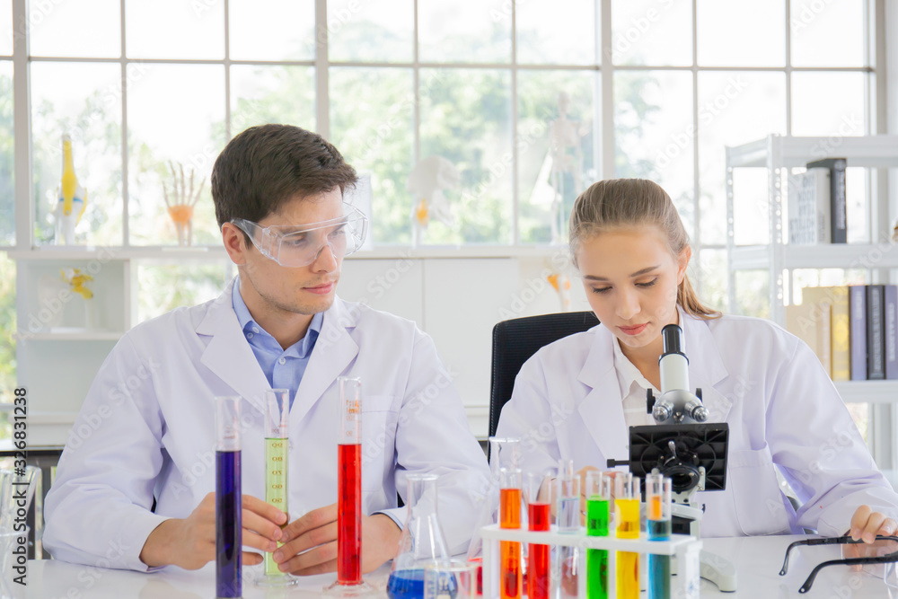 Poster male and female scientists working in a science laboratory with various equipment in the laboratory.