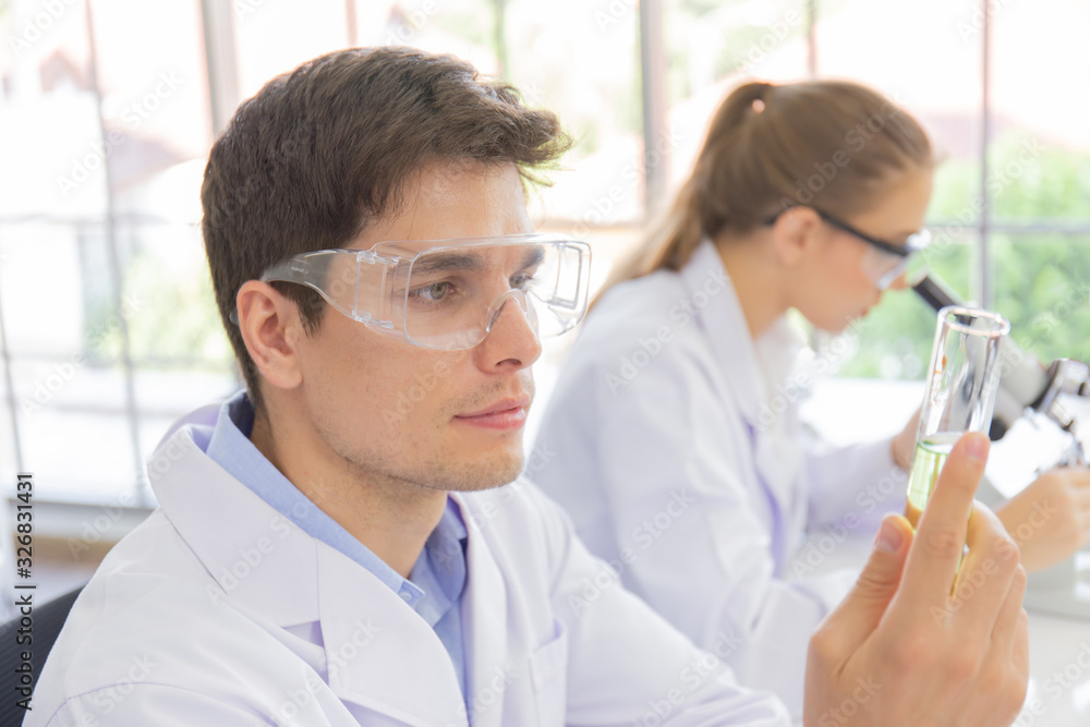 Poster male and female scientists working in a science laboratory with various equipment in the laboratory.