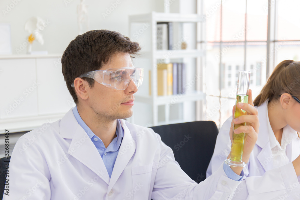 Poster male and female scientists working in a science laboratory with various equipment in the laboratory.