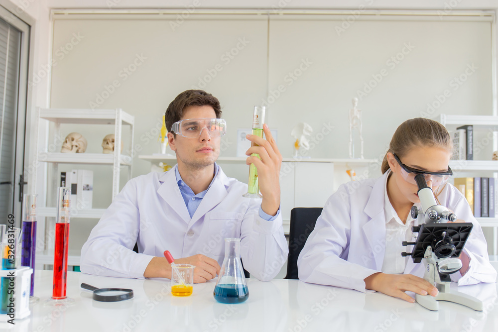 Poster male and female scientists working in a science laboratory with various equipment in the laboratory.