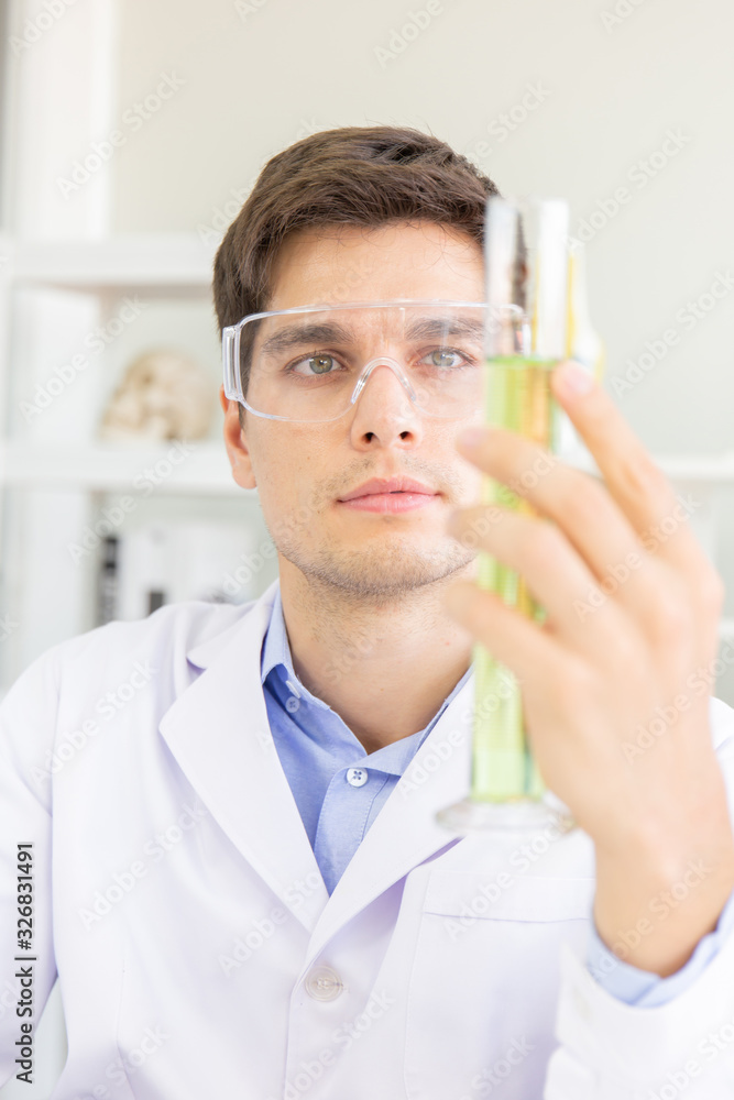 Poster A male scientist working in a science lab with various equipment in the lab