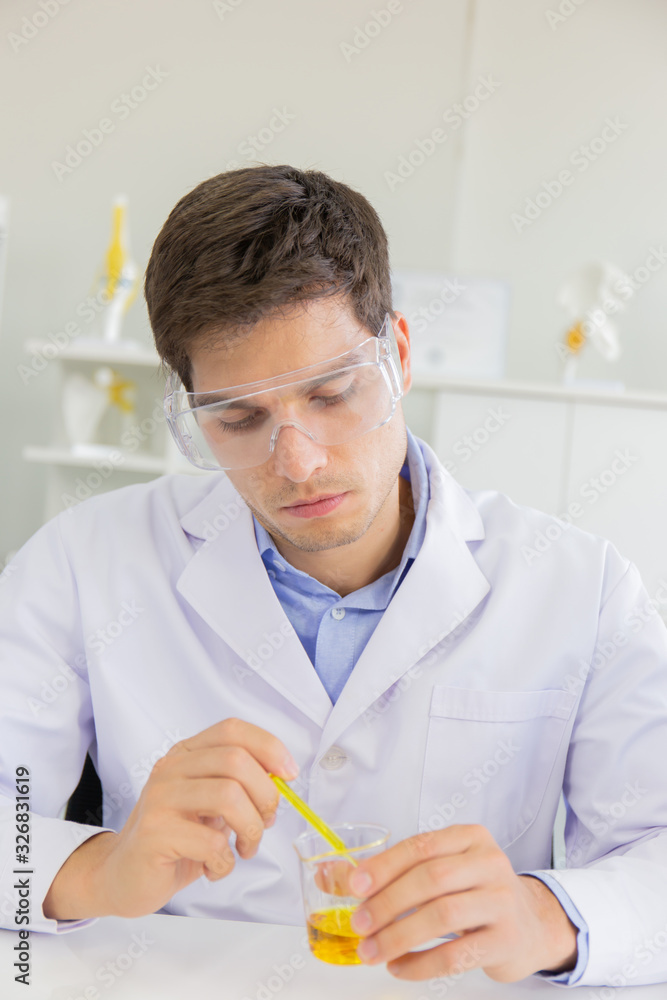 Poster A male scientist working in a science lab with various equipment in the lab