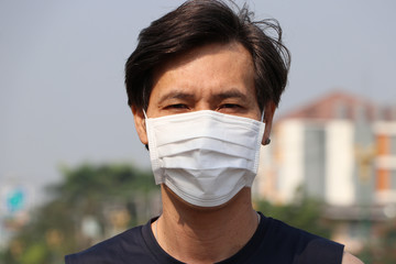 Masked Asian man prevent germs. concept of Tiny Particle protection.