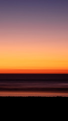 Soft sunset over dark fiery red ocean