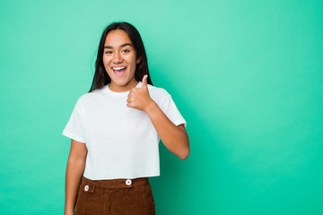 Young mixed race indian woman isolated smiling and raising thumb up
