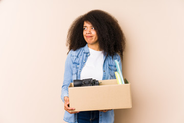 Young afro woman moving home isolated Young afro woman confused, feels doubtful and unsure.