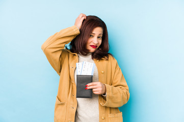 Middle age latin woman holding a passport isolated being shocked, she has remembered important...