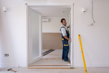 carpenters installing glass door with a wooden frame