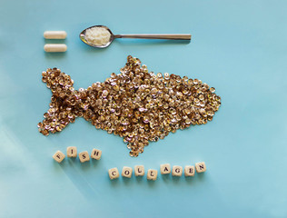 fish collagen concept. fish Collagen powder and capsules on blue background. copyspace for text. Beauty and spa concept.