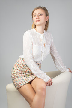 Beautiful fashion woman in skirt and a white shirt in studio