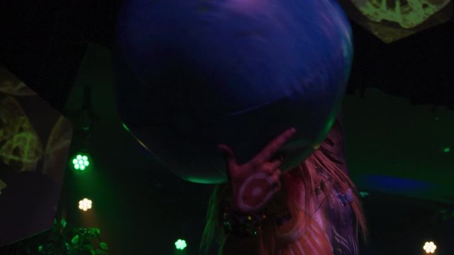 Female performer dressed up as earth, spinning the globe - shot on RED