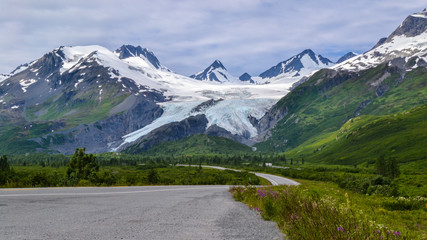 Beautiful Worthington glacier by the highway. Winding road in the mountains Alaska landscape background