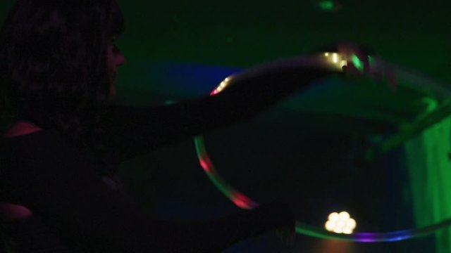 Female performer spins with a colorful hula hoop - Slow Motion - shot on RED