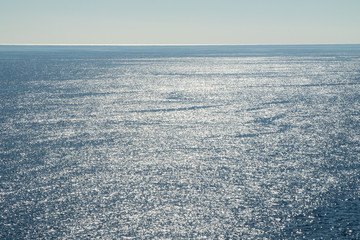Naklejka na ściany i meble Sunny day sea. Reflection of the sun in the sea against the sky, on the surface of the sea.