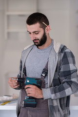 the worker holding a hand drilling machine