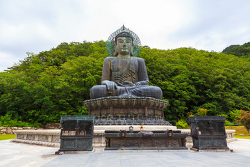 Fototapeta na wymiar Asia Chinese tourist pray at the huge Buddha in the Sinheungsa Temple at Seoraksan National Park, South Korea