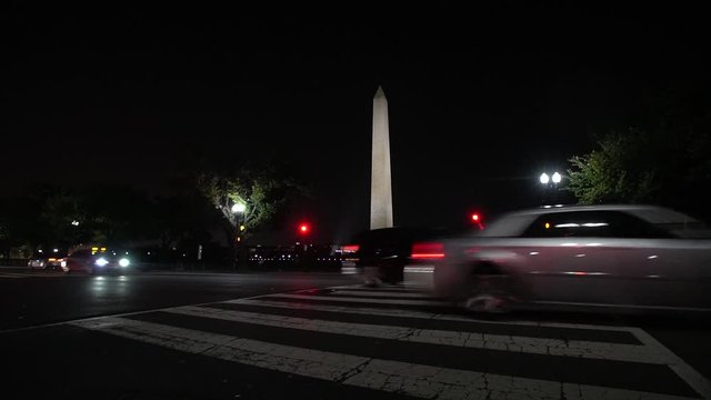 Pedestrian crossing and traffic at night near Washington Monument