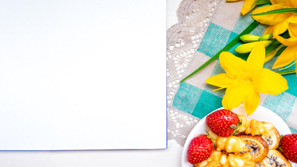 Valentine's day strawberry cookies hearts with coffee, with yellow flowers on a napkin for a note