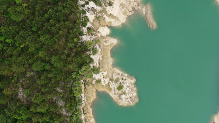 Aerial top down view of Lake Grahovo in mountains. Beautiful landscape of Montenegro nature. Emerald water of Grahovsko Jezero. Sand and stone coast. Forest with green trees. Niksic, Montenegro.