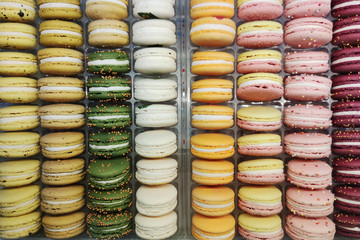 Macaroon cakes of different colors on the counter in a candy store or shop.
