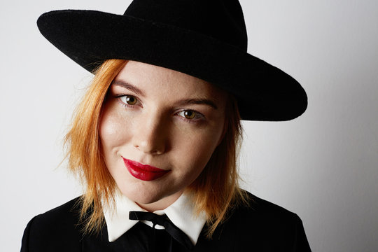 Close-up portrait of hipster girl wearing black dress and hat. Isolated.