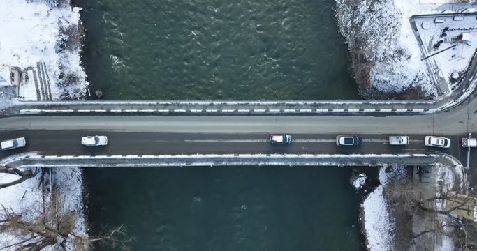 Top Aerial Overhead Wide Shot On A Bridge And River, Cars Traffic. Winter Snowy Shot