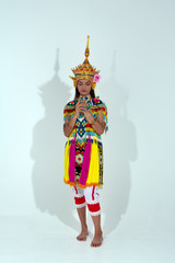 The beautiful woman wearing Thai Tradition southern costume and put headdress on her head,standing on white background,folk dance,black shadow reflection on white background