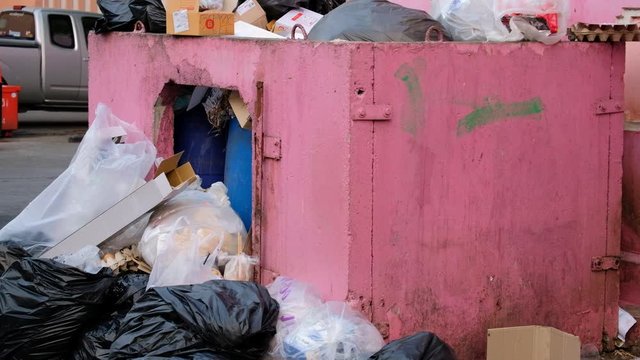Overflowing Trash Dumpster Inner City Street, TILT DOWN