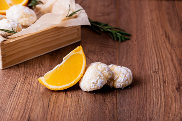 Shortbread orange biscuits with sprigs of semarin, with fresh orange and juice on the table.