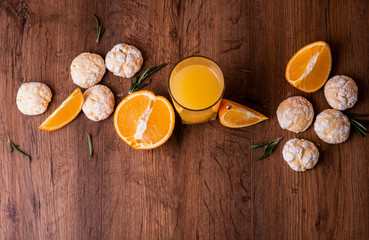 Obraz na płótnie Canvas Shortbread orange biscuits with sprigs of semarin, with fresh orange and juice on the table.