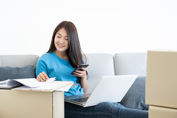 businesswoman working relaxing by laptop computer and mobile phone on sofa at home morning