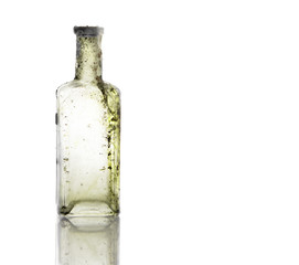 Vintage oil and tincture glass bottle weathered on white background. Old bottle with calcium deposits
