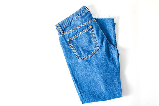 dark blue denim pants on a white background. minimalistic fashion concept. flat lay, copy space