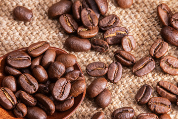 Scattered coffee beans on burlap.