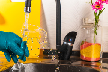 water purification specialist tap water pours into a glass flask.