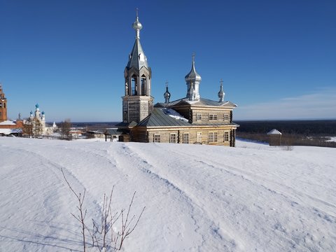 Old church made of wood on a background of blue sky in winter